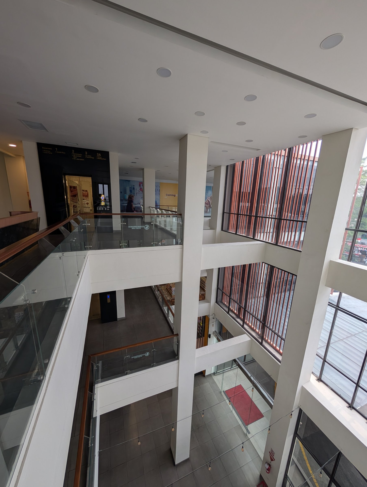Interior corridor leading to the lifts and stairs, with large windows