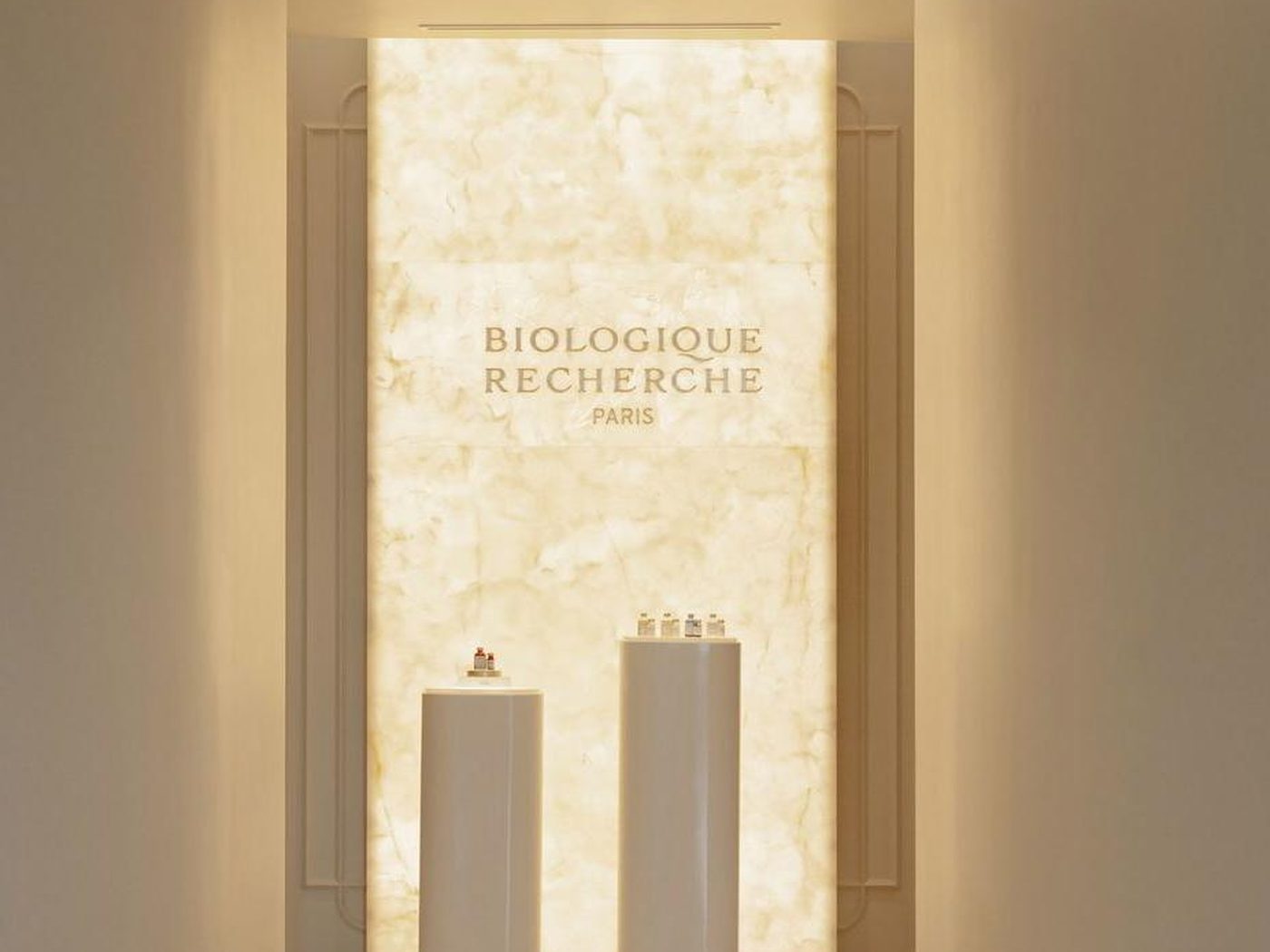Concept image of a foyer with a backlit stone wall and two product pedestals