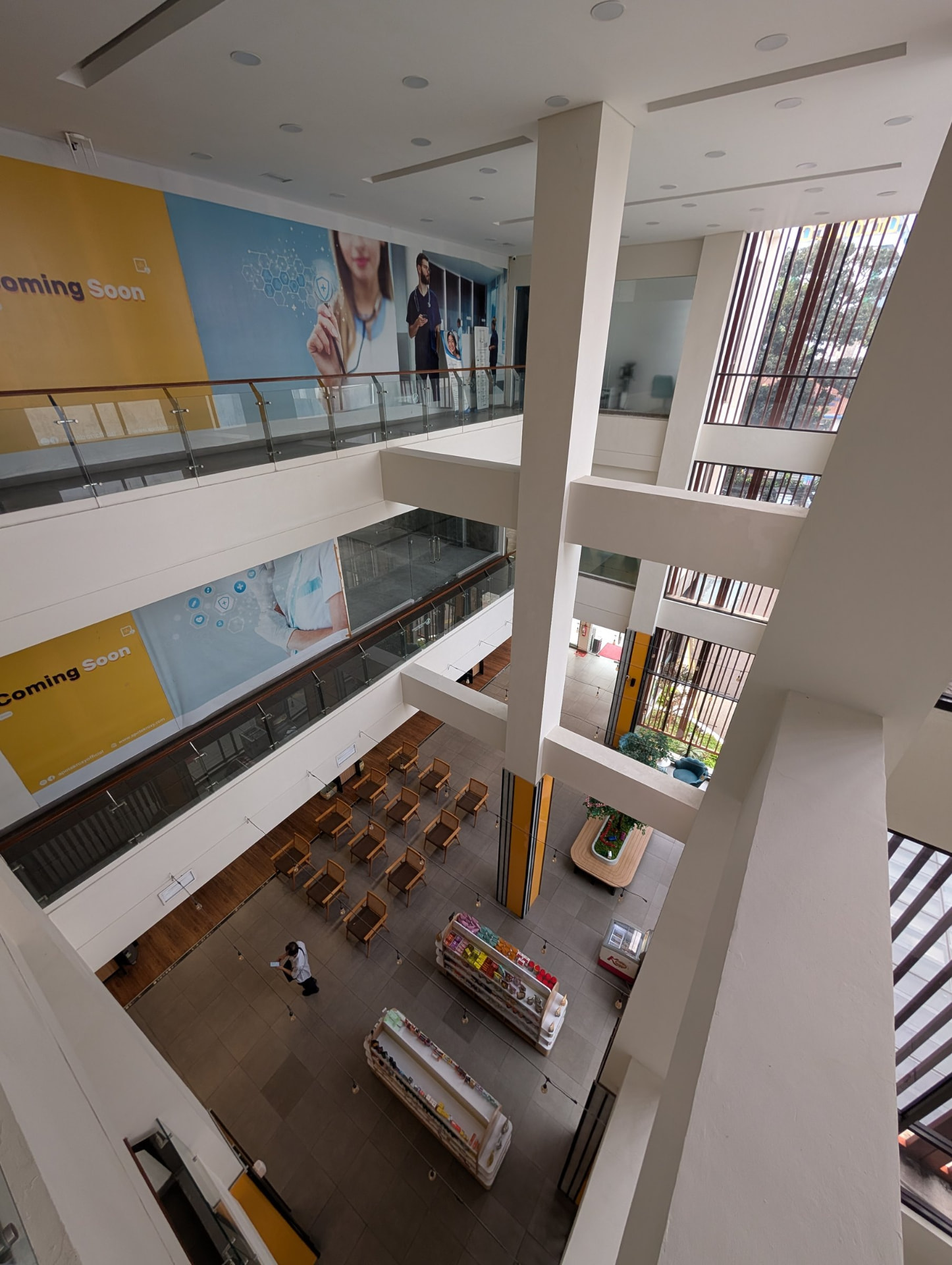 Ground-floor waiting area with wooden chairs and Coming Soon panels above